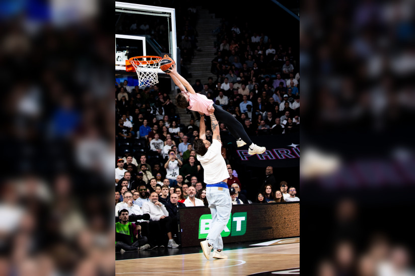 Juan Scelzo, star du Stade Français rugby, aidant un enfant à dunker lors d'une animation au Paris Basketball.