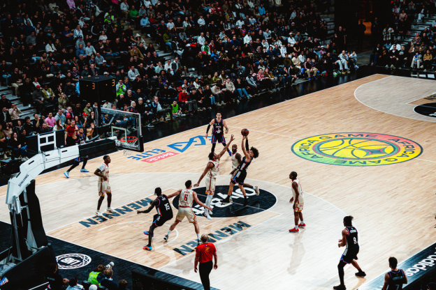 Campagne #36528 - Vue panoramique spectaculaire de l'Adidas Arena à Paris plongée dans une ambiance de show avec jeux de lumières bleus et violets et lasers avant un match du Paris Basketball.