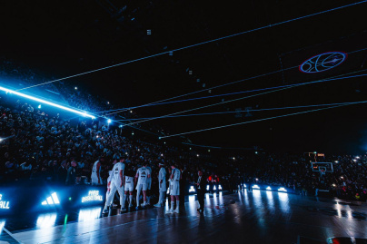 Entrée des joueurs sur le terrain avec un impressionnant jeu de lumières bleues et de lasers dans l'obscurité de l'Adidas Arena.