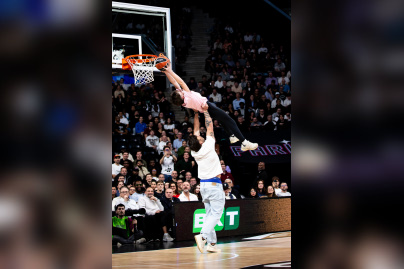 Juan Scelzo, star du Stade Français rugby, aidant un enfant à dunker lors d'une animation au Paris Basketball.
