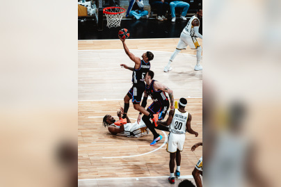 Justin Robinson du Paris Basketball en pleine action offensive, transperçant la défense de l'ASVEL en EuroLeague à l'Adidas Arena.