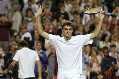 Gilles Simon of France celebrates defeating Roger Federer (rear) of Switzerland at the Rogers Cup tennis tournament in Toronto July 23, 2008. REUTERS/Mark Blinch (CANADA)