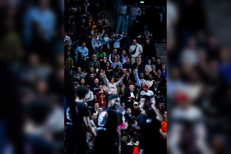 Plan sur un public nombreux, souriant et enthousiaste dans les gradins de l'Adidas Arena pour soutenir le Paris Basketball.