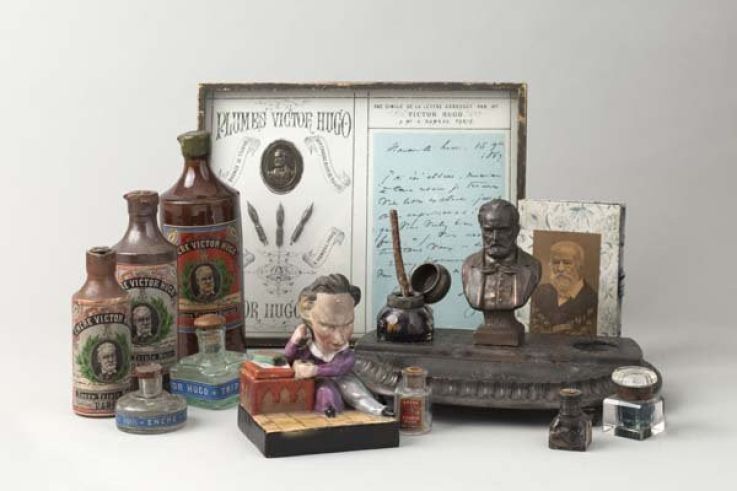 Plumes "Victor Hugo", bouteilles d'encre "Victor Hugo", encrier en céramique, encrier en métal, carnet avec effigie de Victor Hugo. Paris, Maison de Victor Hugo. 
