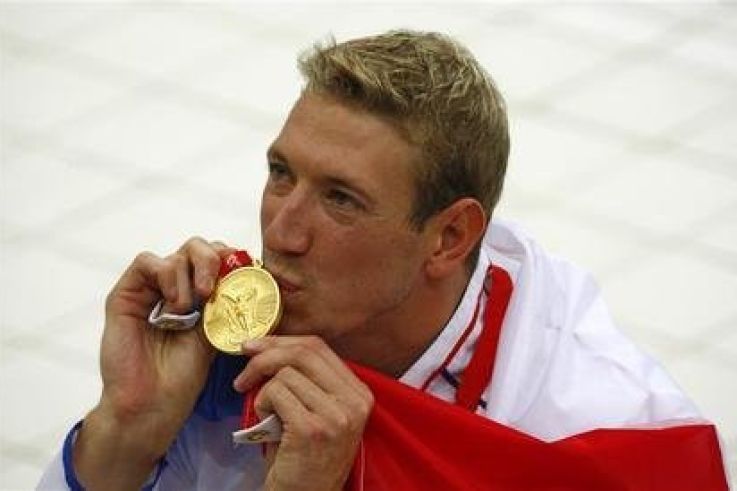 Alain Bernard of France kisses his gold medal for the men's 100m freestyle swimming final during the Beijing 2008 Olympic Games at the National Aquatics Centre, August 14, 2008.     REUTERS/David Gray (CHINA)