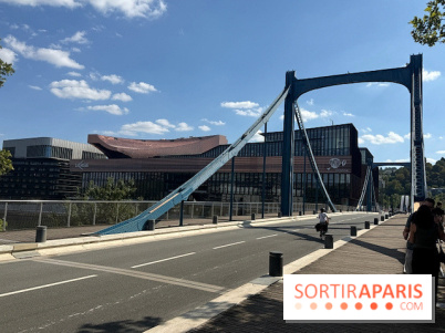 Pont suspendu bleu sur l'île Seguin près d'un complexe cinématographique