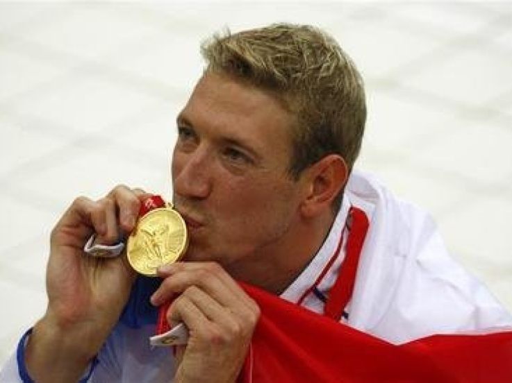 Alain Bernard of France kisses his gold medal for the men's 100m freestyle swimming final during the Beijing 2008 Olympic Games at the National Aquatics Centre, August 14, 2008.     REUTERS/David Gray (CHINA)