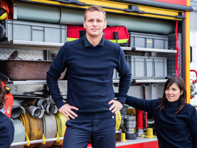 1083 présente son pull confectionné à partir de pulls de pompiers recyclés