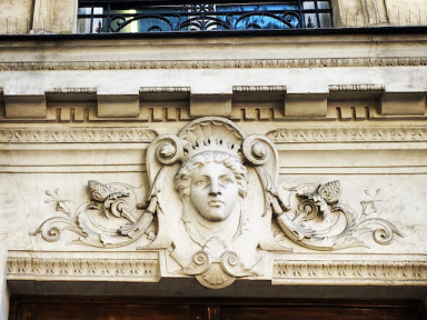 Pourquoi y a t-il des visages au-dessus des portes d'immeubles à Paris ?