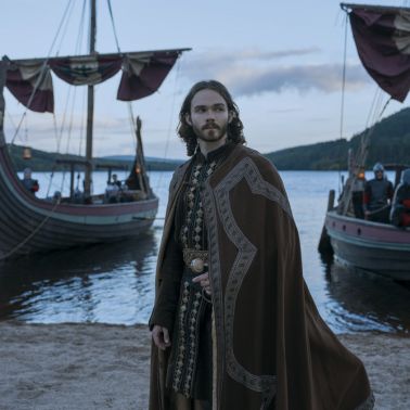 Bloodaxe - Homme viking en tenue traditionnelle devant des navires drakkars
