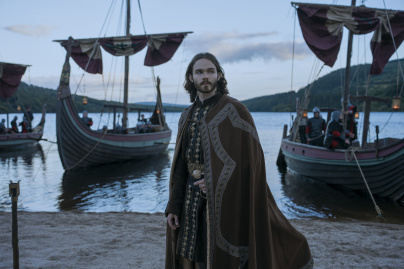 Bloodaxe - Homme viking en tenue traditionnelle devant des navires drakkars